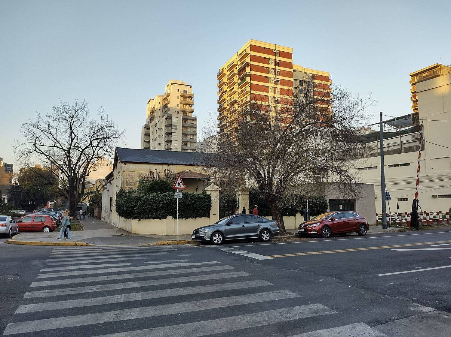 Esquina de Villa Urquiza con casas bajas y torres al atardecer